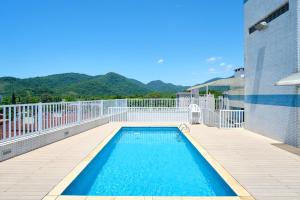 a swimming pool on a balcony with mountains in the background at PS5: Aproveite Ubatuba! Apto Completo & Bem Localizado in Ubatuba