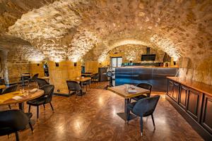 a restaurant with tables and chairs in a stone room at Domaine de la Klauss & Spa, Restaurant Gastronomique Le K in Montenach