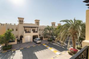 a building with a car parked in a parking lot at Nasma Luxury Stays - Exquisite 4BR Villa, with a Private Pool in Ras al Khaimah