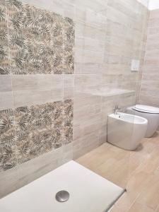uma casa de banho com um WC e uma parede de azulejos em Messina’s apartment em Messina