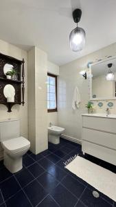 a bathroom with a toilet and a tub and a sink at Maison Terrasse Doña Irma in Cambados +45 photos