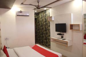 ZirakpurにあるHOTEL FIRSTのベッドルーム1室(ベッド1台、壁掛けテレビ付)