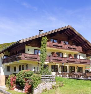 a large building with tables and chairs at DEVA Hotel-Restaurant Fischerwirt inklusive Chiemgau Card in Ruhpolding