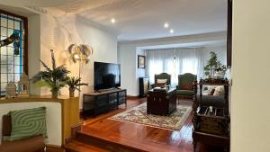 a living room with a television and a living room with a couch at Maison Terrasse Doña Irma in Cambados