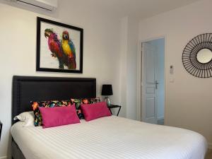 a bedroom with a bed with two birds on the wall at Villa 418 in Saint-Raphaël