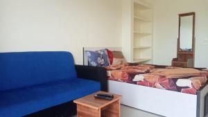 Habitación con cama, sofá y mesa. en Aranmagan Paradise, en Tiruchchendūr