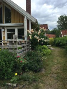 a house with a fence with flowers on it at Ferienhaus zum Krakower See in Krakow am See