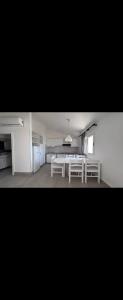 a white kitchen with a white table in a room at Kamarina Resort in Ragusa