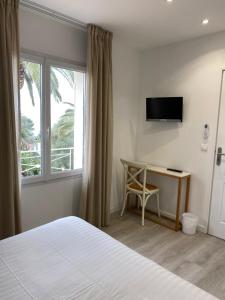 a bedroom with a bed and a desk and a window at Villa 418 in Saint-Raphaël