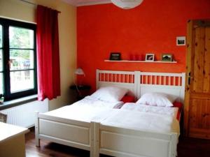 um quarto com uma cama branca e uma parede vermelha em Ferienwohnung Wichmann 