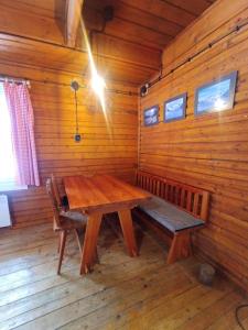 una sala da pranzo in legno con tavolo e panca in legno di Chatky u potoka chatka n3 a Olešnice v Orlických horách