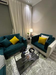- un salon avec un canapé bleu et des oreillers jaunes dans l'établissement شقة بالملقا بدخول ذاتي, à Riyad