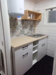 a small kitchen with white cabinets and a sink at Chatky u potoka chatka n3 in Olešnice v Orlických horách