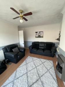a living room with two black couches and a ceiling fan at Lovely 2-Bed Apartment in the very Centre of March in March