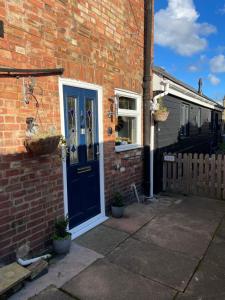 a brick house with a blue door and a window at Lovely 2-Bed Apartment in the very Centre of March in March