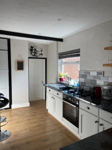 a kitchen with white cabinets and a stove top oven at Lovely 2-Bed Apartment in the very Centre of March in March