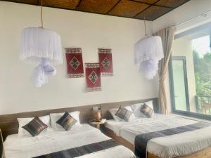 1 dormitorio con 2 camas y ventana en Puluong Aroma, en Hương Bá Thước