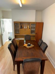 a dining room with a wooden table and chairs at Cardiff Grangetown Stylish 3Bed House. in Cardiff