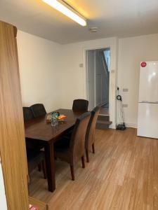 a dining room with a table and chairs and a refrigerator at Cardiff Grangetown Stylish 3Bed House. in Cardiff