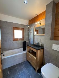 a bathroom with a tub and a toilet and a sink at Charming, cosy chalet nestled in a breathtaking surrounding with spectacular, stunning mountain views in La Chapelle-dʼAbondance