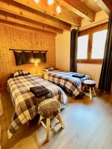 1 dormitorio con 2 camas en una cabaña de madera en Charming, cosy chalet nestled in a breathtaking surrounding with spectacular, stunning mountain views, en La Chapelle-dʼAbondance