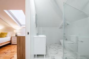 uma casa de banho com uma cabina de duche em vidro e uma cama em Portugal Portfolio - Seascape Apartment Unit 1 em Estoril