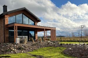 a brick house with glass windows in a field at Czaple Resort in Stare Czaple