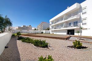 a white building with plants in front of it at Apartamento Rossio in Albufeira