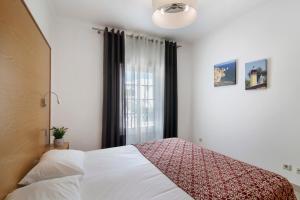 a bedroom with a bed and a window at Apartamento Rossio in Albufeira +12 photos