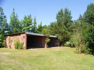 a brick building in a field next to trees at Ferienbungalow Nautik in Hoppenwalde
