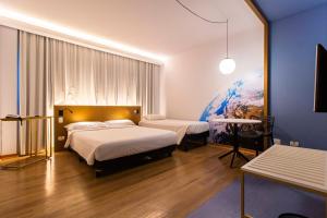 a hotel room with two beds and a tv at Hotel Euro Suíte Curitiba Batel By Nacional Inn in Curitiba