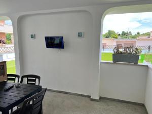a dining room with a table and a tv on a wall at Les Amis appartamento anzio in Anzio