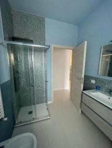 a bathroom with a shower and a toilet and a sink at Les Amis appartamento anzio in Anzio +16 photos