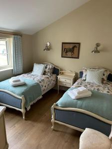 1 dormitorio con 2 camas y ventana en A family and dog friendly haven, The Hayloft., en Saxmundham