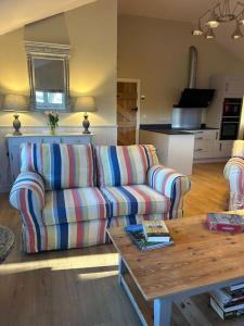 a living room with a couch and a coffee table at A family and dog friendly haven, The Hayloft. in Saxmundham