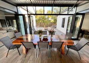 a dining room with a wooden table and chairs at Stories @ Marloth in Marloth Park
