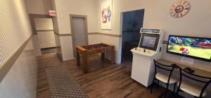 ein Zimmer mit einem Fernseher und einem Tisch mit einem Videospiel in der Unterkunft Hotel Gracher Praia in Balneário Camboriú