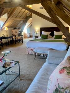 a bedroom with two beds and a couch in a attic at Hôtel du Domaine de La Groirie - Le Mans in Trangé