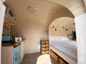 1 dormitorio pequeño con 1 cama y cocina en Prosecco - Lydcott Glamping Cornwall, sea views en East Looe