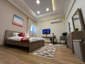 a bedroom with a bed and a tv and a couch at Sada Compound (Women Only) سيدات فقط in Riyadh