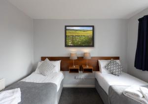 a bedroom with two beds and a picture on the wall at The Angel Hotel in Alton