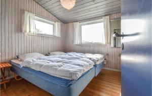 BøjdenにあるAmazing Home In Faaborg With 4 Bedrooms, Sauna And Wifiの大型ベッド1台(窓2つ付)