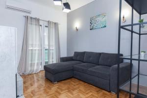 ein Wohnzimmer mit einem Sofa und einem Fenster in der Unterkunft Modern Cozy 1 Bd Piraeus Perfection Apt in Piräus