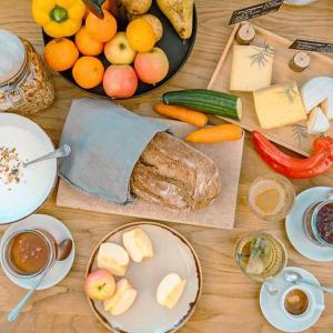 a table topped with plates of food and fruits and vegetables at Silo Design & Boutique Hostel Basel in Basel