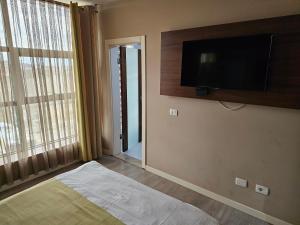 um quarto com uma televisão de ecrã plano na parede em HOTEL BENITA em Peje