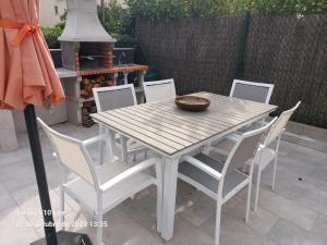 Une table et des chaises en bois sont disponibles sur la terrasse. dans l'établissement Casa parque Natural Montseny con piscina, barbacoa y Chimenea, à San Antonio de Vilamajor