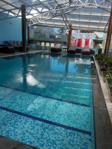 a large swimming pool with blue tiles in a building at Royal Tulip Luxury Hotel, Kufri, Shimla in Shimla