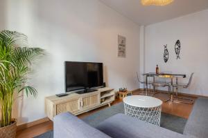 a living room with a flat screen tv on a stand at Mouraria Doll's House in Lisbon