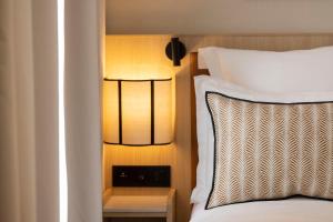 a bedroom with a bed and a nightstand next to a bed sidx sidx sidx at Hotel Duminy-Vendome in Paris