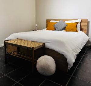 a large bed with yellow pillows and a table at Au coron des Anges - Havré - Mons - Pairi Daiza - Shape in Mons